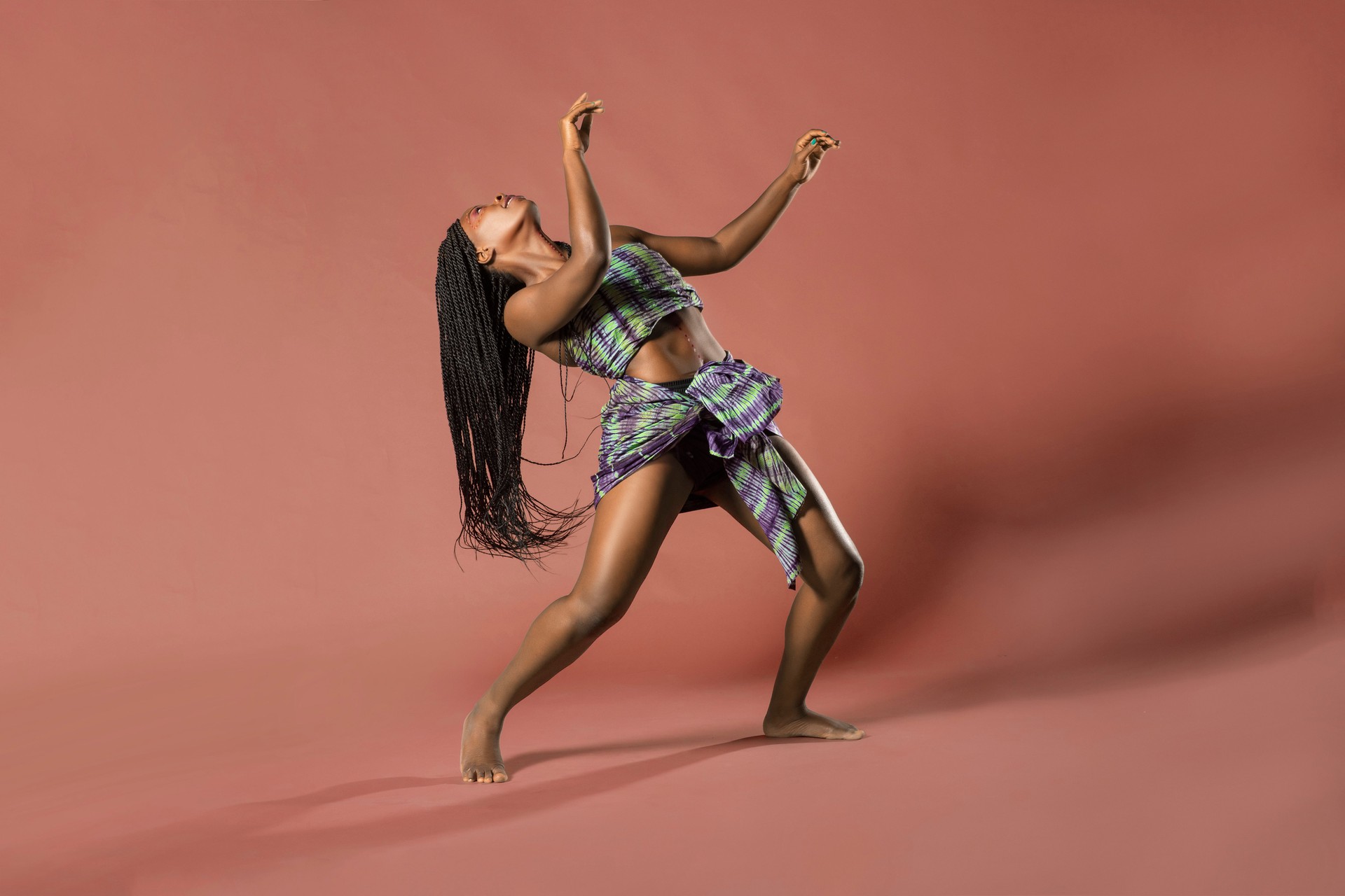 Young Woman Dancing Against Brown Background